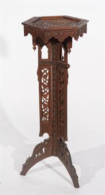 Lot 554 - AN INDIAN CARVED TORCHERE with hexagonal top on a open fretwork column