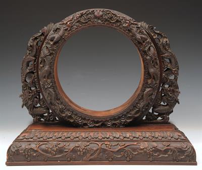 Lot 643 - A CHINESE HARDWOOD STAND of circular form with dragons carved to the border and on a heavy carved