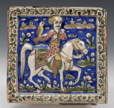 Lot 682 - A QAJAR SQUARE TILE with equestrian figure holding a falcon