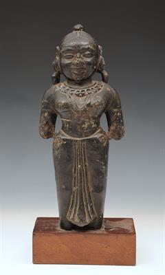 Lot 710 - AN INDIAN CARVED STONE DEITY on a later hardwood stand