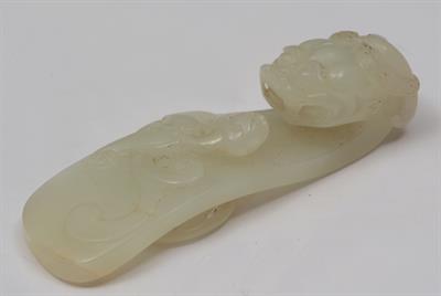 Lot 728 - A CHINESE PALE JADE CARVED BELT HOOK