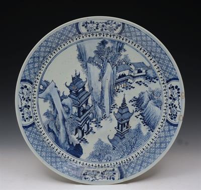 Lot 733 - A CHINESE BLUE AND WHITE PORCELAIN CHARGER with central pavilion and river scene within a panelled