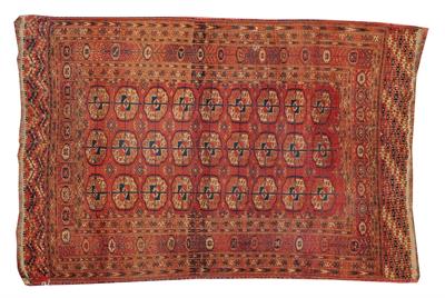 Lot 74 - A TEKKE TURKOMAN BRICK RED GROUND RUG decorated with three rows of nine guls within a multiple