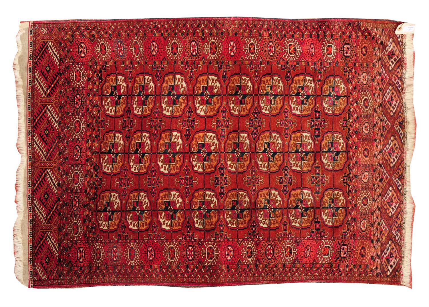 Lot 75 - A TURKOMAN DARK RED GROUND SMALL RUG decorated with three rows of eight guls within a multiple