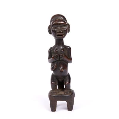 Lot 371 - A BEMBE/HAMBA WOODEN FIGURE carved in the form of a woman seated upon a stool