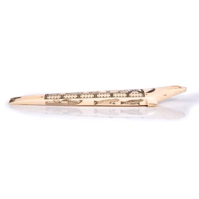 Lot 392 - AN INUIT CARVED WALRUS TUSK CRIBBAGE BOARD modelled as a seal with scrimshaw decoration