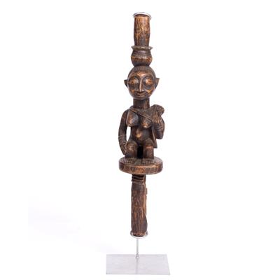 Lot 393 - A YORUBA WOODEN DANCE WAND with carved seated female figure holding a bag
