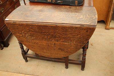 Lot 104 - AN ANTIQUE OAK GATELEG TABLE with oval top and bobbin and reel turned legs united by stretchers