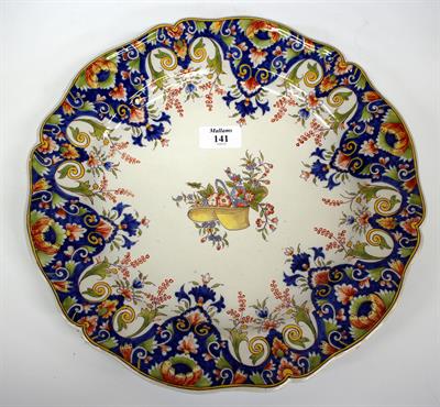 Lot 141 - AN OLD CONTINENTAL FAIENCE CHARGER centrally decorated in coloured enamels with flowers in a hat and
