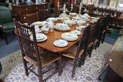 Lot 157 - A REGENCY STYLE DINING TABLE standing on two tripod bases