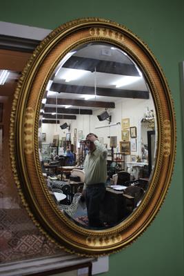 Lot 185 - A GILT FRAMED OVAL HANGING WALL MIRROR 66cm wide x 87cm high