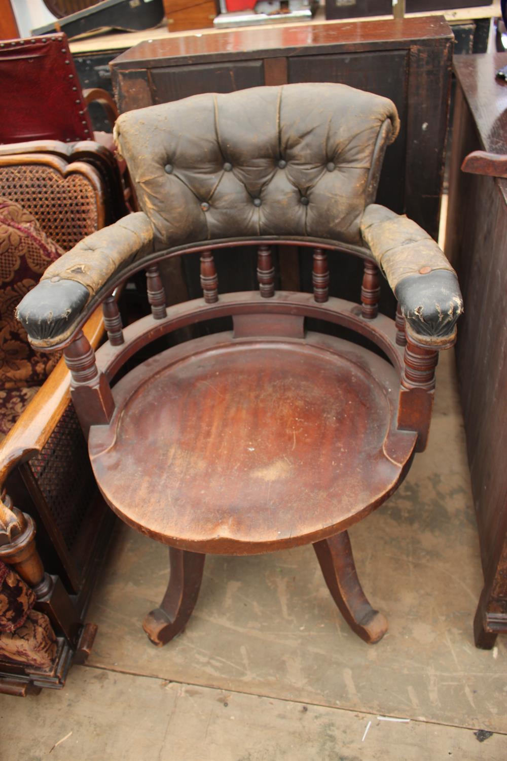 Lot 212 - AN EARLY 20TH CENTURY HARDWOOD LEATHER UPHOLSTERED DESK CHAIR the arching upholstered back with