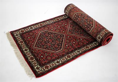 Lot 284 - A MODERN ORIENTAL WINE GROUND RUNNER with five diamond designs to the central field