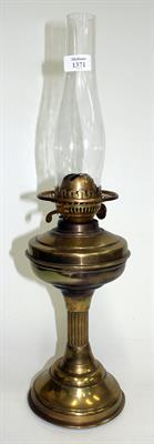 Lot 350 - AN OLD BRASS OIL LAMP with reeded column support on circular spreading base