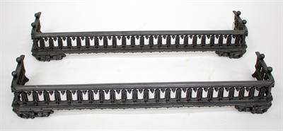 Lot 372 - A PAIR OF VICTORIAN CAST IRON FENDERS each with a pierced facade and foliate scroll feet
