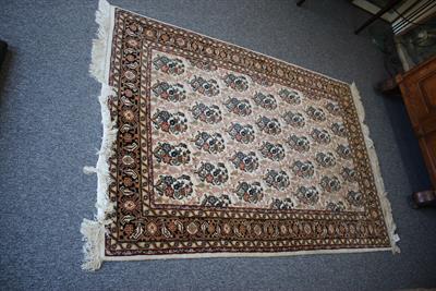 Lot 400 - A DECORATIVE CREAM GROUND RUG with repeating floral design within a multiple banded border 180cm x