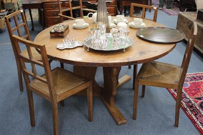 Lot 472 - A LARGE CIRCULAR PINE DINING TABLE the top over three shaped and carved supports 138cm in diameter