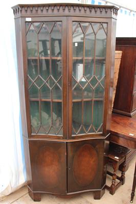 Lot 530 - A REPRODUCTION SERPENTINE CORNER CABINET with astragal glazed doors above two cupboard doors below