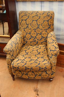 Lot 553 - AN EDWARDIAN UPHOLSTERED ARMCHAIR with turned front feet and brass castors
