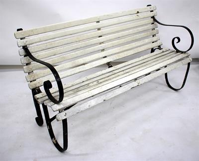 Lot 570 - AN OLD WROUGHT IRON GARDEN BENCH painted in black and white and with wooden slatted seat and back