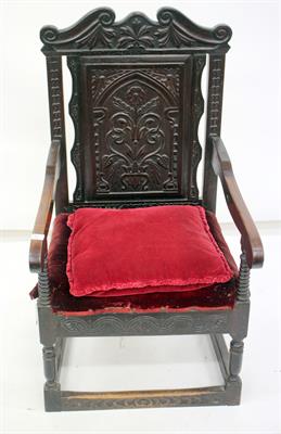 Lot 583 - AN ANTIQUE OAK WAINSCOT CHAIR with carved floral panel back and turned supports