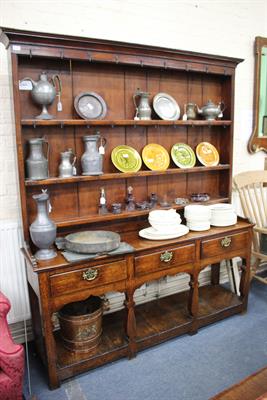Lot 661 - A GEORGE III OAK DRESSER BASE with three drawers above shaped legs united by a pot shelf