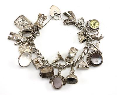 Lot 561 - A HEAVY SILVER CHARM BRACELET