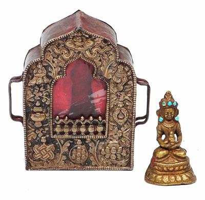 Lot 247 - A TIBETAN PORTABLE SILVER FACED SHRINE embossed with auspicious symbols containing a metal image of