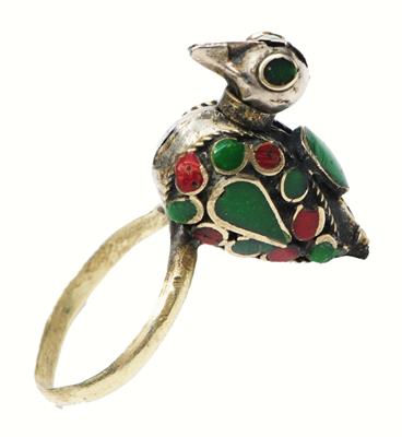 Lot 257 - A MIDDLE EASTERN SILVER RING in the form of a bird inlaid with green and red stones