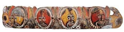 Lot 390 - A PAPUA NEW GUINEA PAINTED AND CARVED WOODEN CEREMONIAL HANGING BOARD decorated with four masks in