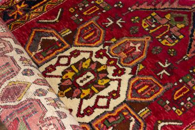 Lot 595 - AN ORIENTAL RED GROUND SMALL RUNNER