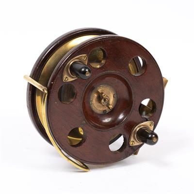 Lot 87 - A WALNUT AND BRASS MOUNTED FISHING REEL with pierced and brass lined star back