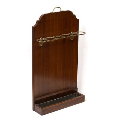 Lot 126 - A MAHOGANY AND BRASS STICK STAND the shaped mahogany back with six brass circular divisions