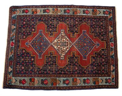 Lot 257 - A PERSIAN RUG the central brick red field with three stepped medallions