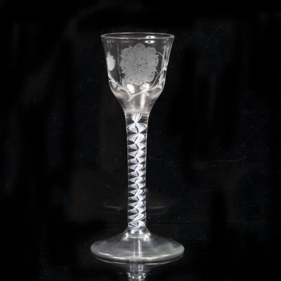 Lot 317 - AN 18TH CENTURY COLOUR TWIST STEM WINE GLASS with engraved floral decoration ogee bowl to a central