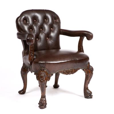 Lot 359 - AN 18TH CENTURY STYLE OAK OPEN ARM LIBRARY CHAIR upholstered in button brown leather and on ornately