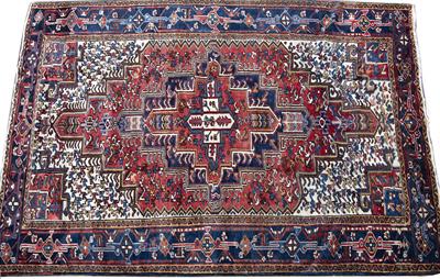 Lot 369 - AN HERIZ RUST GROUND CARPET with central medallion and polychrome stylised decoration within a blue