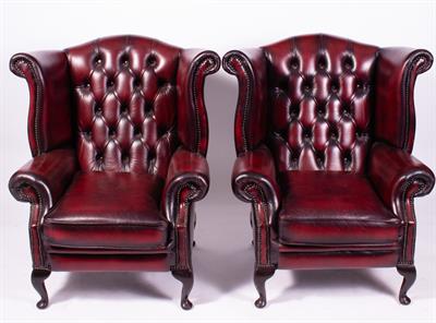 Lot 101 - A PAIR OF RED LEATHER UPHOLSTERED WING BACK ARMCHAIRS