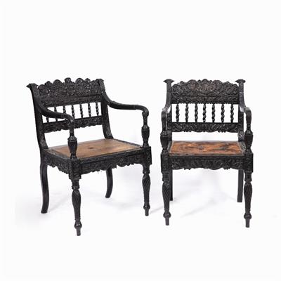 Lot 24 - A NEAR PAIR OF EARLY 19TH CENTURY CEYLONESE CARVED EBONY OPEN ARMCHAIRS the foliate crest rails over
