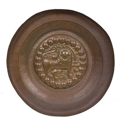 Lot 123 - AN ISLAMIC BRONZE CHARGER the centre embossed with a lion and sabre with traces of gilt