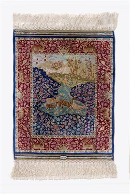 Lot 218 - A PERSIAN MINIATURE SILK RUG woven with deer in a landscape pattern in colours within a red border