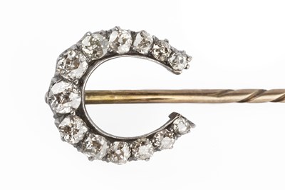 Lot 54 - A diamond stick pin, the horseshoe-shaped...