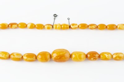 Lot 66 - An amber bead necklace, comprising a single...