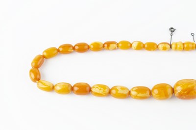 Lot 66 - An amber bead necklace, comprising a single...