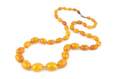 Lot 53 - An amber bead necklace, comprising a single...