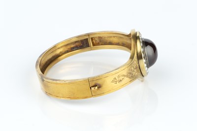 Lot 17 - A late Victorian garnet and half pearl bangle,...