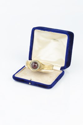 Lot 17 - A late Victorian garnet and half pearl bangle,...