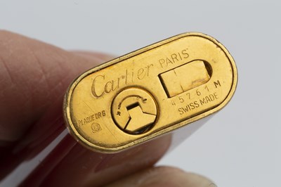 Lot 346 - A gilt metal and burgundy enamel lighter, by...