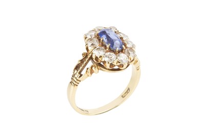 Lot 174 - A sapphire and diamond cluster ring, the oval...