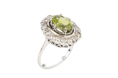 Lot 171 - A peridot and diamond cluster ring, the oval...